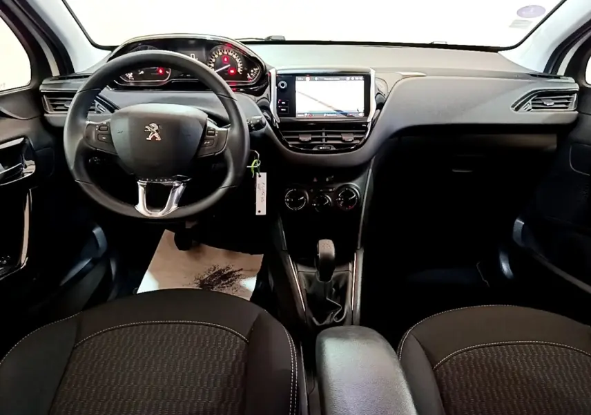 Vue intérieure avant de la Peugeot 208 Puretech 82 S&S Active Business, tableau de bord avec écran tactile et volant noir.