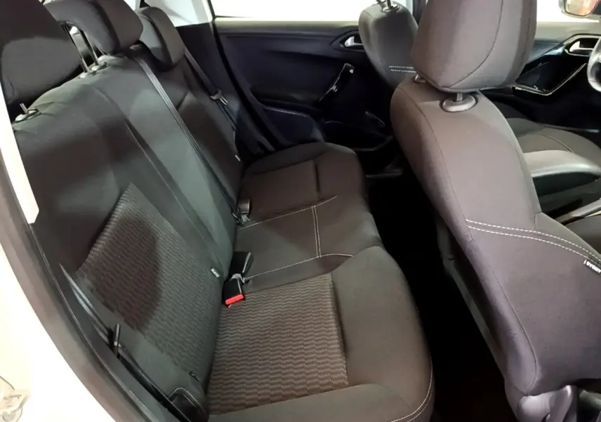 Intérieur arrière de la Peugeot 208 blanche, vue côté gauche, sièges tissu noir avec surpiqûres blanches.