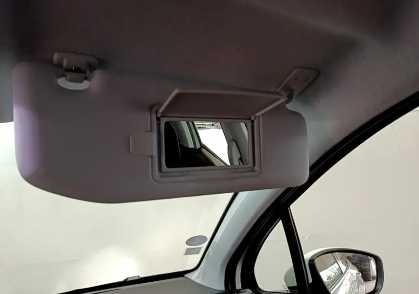 Miroir de courtoisie ouvert sur pare-soleil intérieur côté conducteur d'une Peugeot 208 blanche, vue rapprochée.