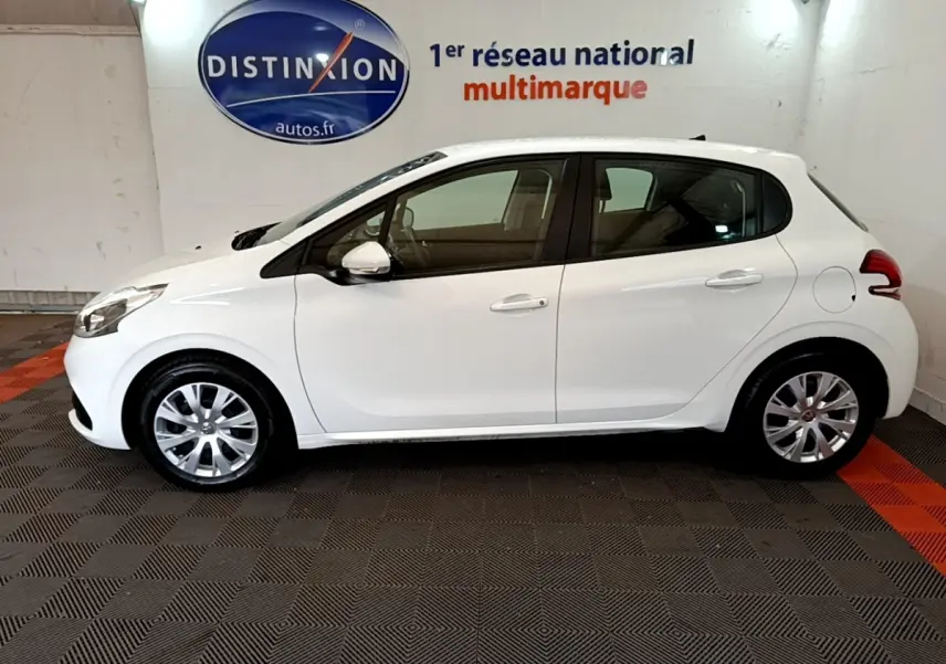 Profil côté gauche d'une Peugeot 208 blanche Puretech 82 S&S Active Business de 2018, dans un showroom intérieur.