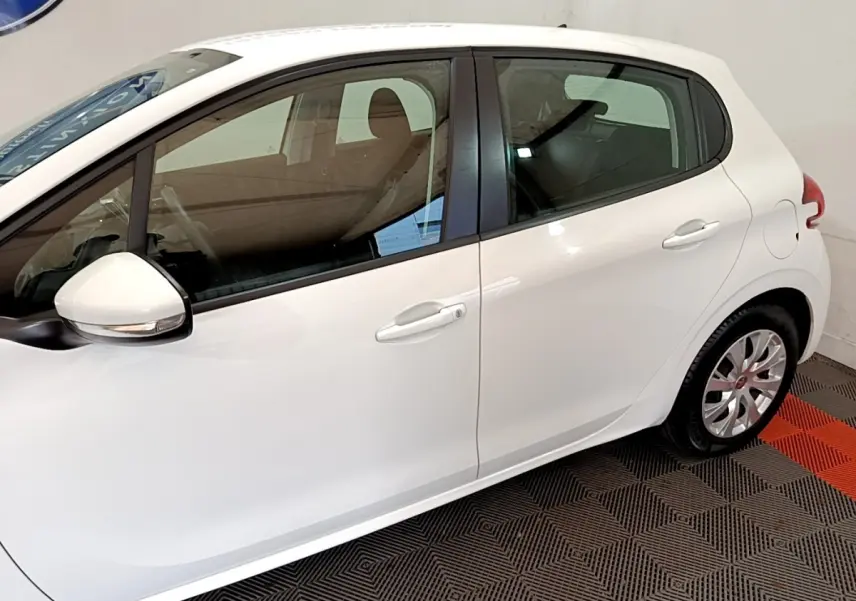 Vue latérale droite d'une Peugeot 208 blanche, mettant en valeur les portes et les rétroviseurs extérieurs.