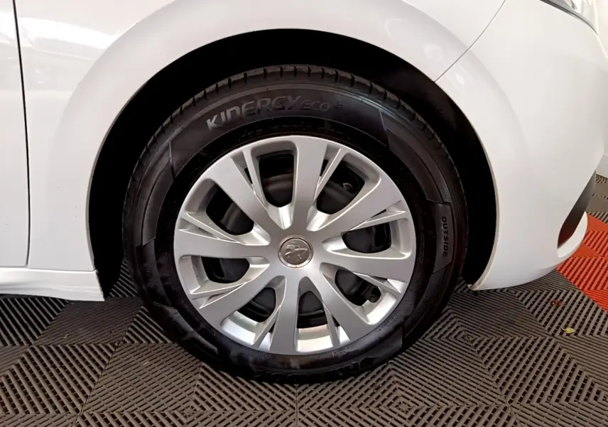 Gros plan sur la roue avant droite d'une Peugeot 208 blanche, avec jante en alliage et pneu Kinergy Eco².
