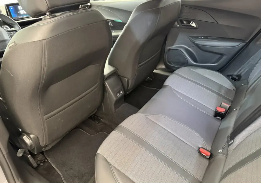 Vue arrière intérieure du Peugeot 2008 gris clair, sièges arrière en tissu et cuir avec ports USB visibles.