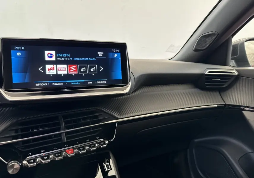 Vue intérieure côté passager du tableau de bord noir avec écran tactile 10 pouces et finitions carbone du Peugeot 2008 gris clair.