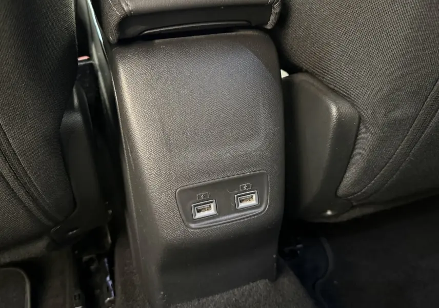 Prise double USB arrière sur console centrale noire entre les sièges arrière du Peugeot 2008 gris clair 2023.