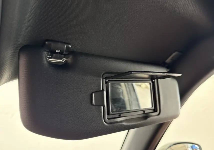 Miroir de courtoisie ouvert sur pare-soleil côté conducteur dans l’habitacle d’un Peugeot 2008 gris clair.