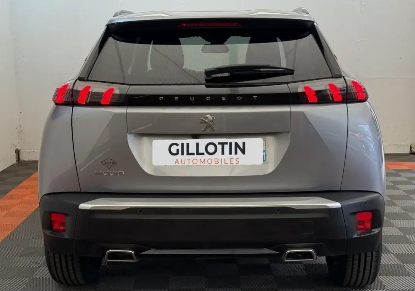 Vue arrière d'un Peugeot 2008 gris clair 2023 avec feux LED caractéristiques et double sortie d'échappement.