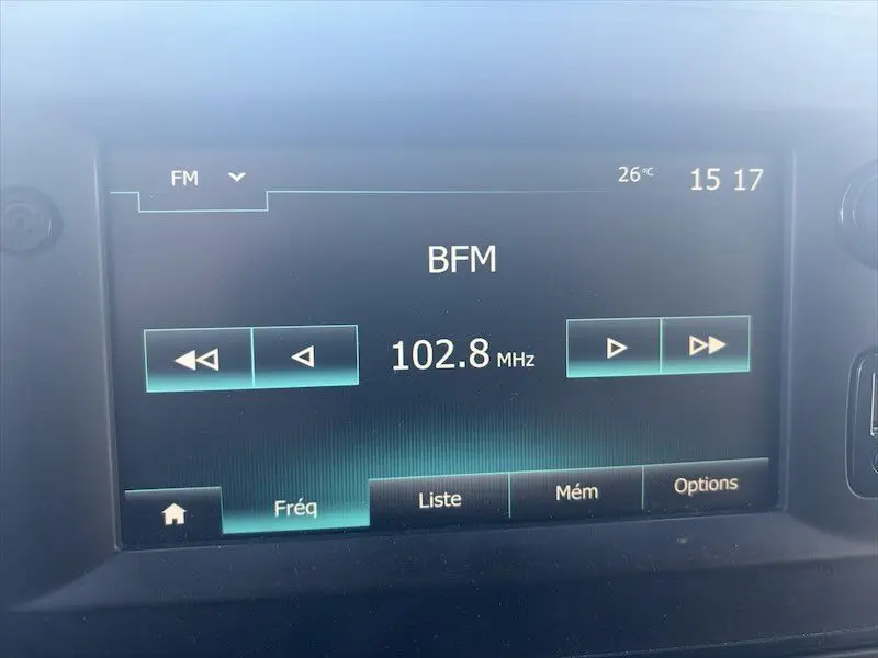 Écran tactile de la radio FM affichant la station BFM à 102,8 MHz dans un Renault Master blanc.