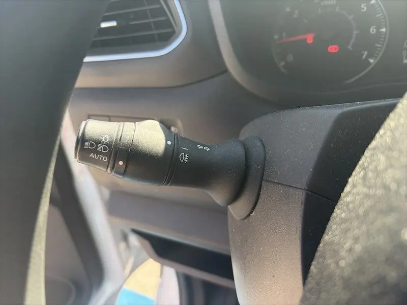 Gros plan sur la manette des feux et clignotants à gauche du volant dans l'habitacle du Renault Master blanc 2021.
