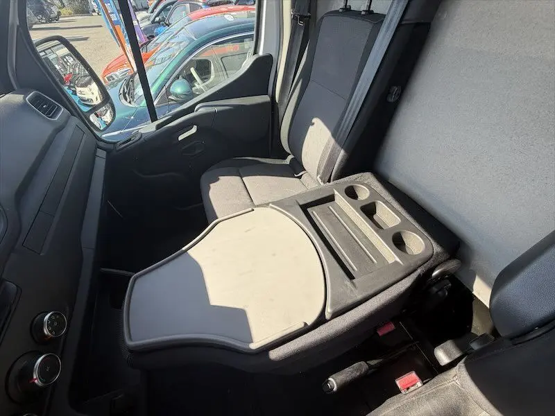 Vue intérieure côté passager du Renault Master blanc 2021, avec tablette rabattable et porte-gobelets intégrés.