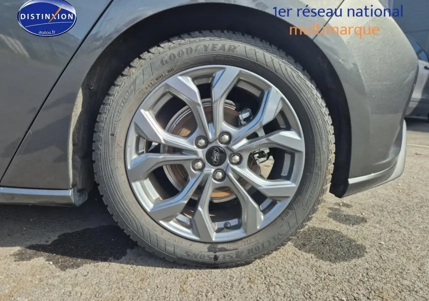 Gros plan sur la roue avant gauche avec jante alu grise d'une Ford Focus gris magnétique 2024.