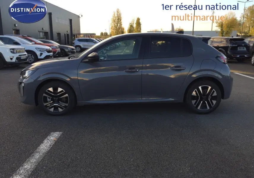 Profil côté gauche d'une Peugeot 208 hybride gris selenium métal garée sur un parking extérieur au coucher du soleil.