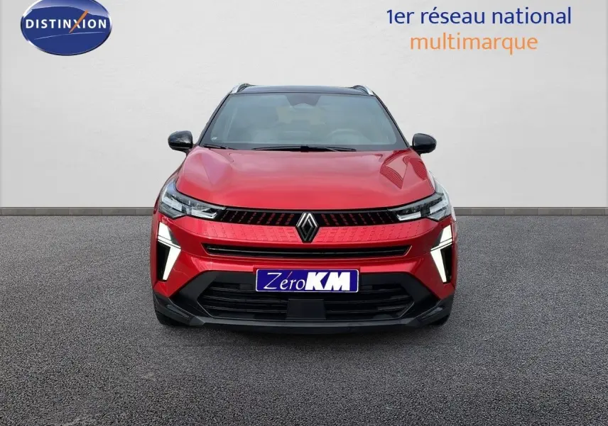Vue frontale d'un Renault Captur E-Tech hybride rouge passion avec toit noir et feux LED allumés.