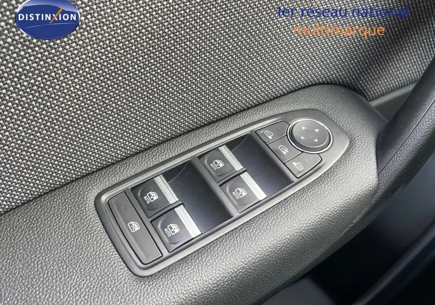 Panneau de commandes des vitres électriques côté conducteur sur porte intérieure en tissu gris et plastique noir.