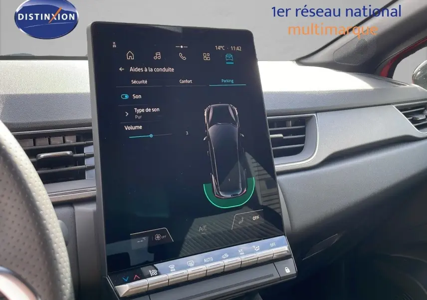 Vue rapprochée de l'écran tactile central du tableau de bord du Renault Captur rouge passion 2025, affichant les aides à la conduite.