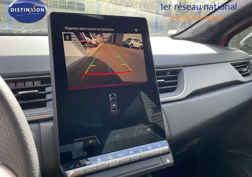 Vue intérieure du tableau de bord du Renault Captur rouge Passion 2025, avec écran tactile affichant la caméra de recul.