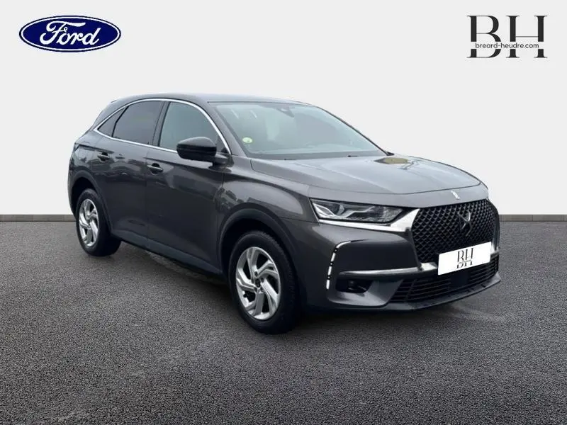 DS7 Crossback gris Platinium vu en 3/4 avant droit, mettant en valeur sa calandre distinctive et ses phares LED.