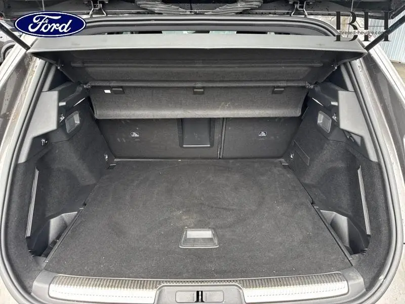 Coffre ouvert vu de l'arrière d'un DS7 Crossback gris Platinium, espace de chargement propre et spacieux.