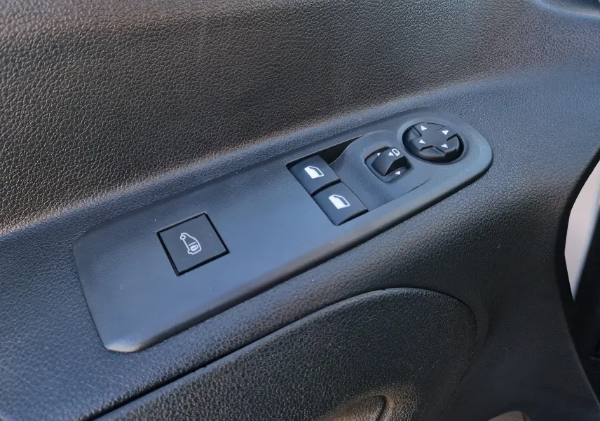 Gros plan sur les commandes de réglage des rétroviseurs et vitres côté conducteur du Peugeot Partner blanc 2021.