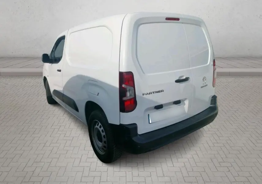 Vue 3/4 arrière droite d’un Peugeot Partner blanc 2021 utilitaire avec plaque Abeilhe Autos sur un terrain extérieur.