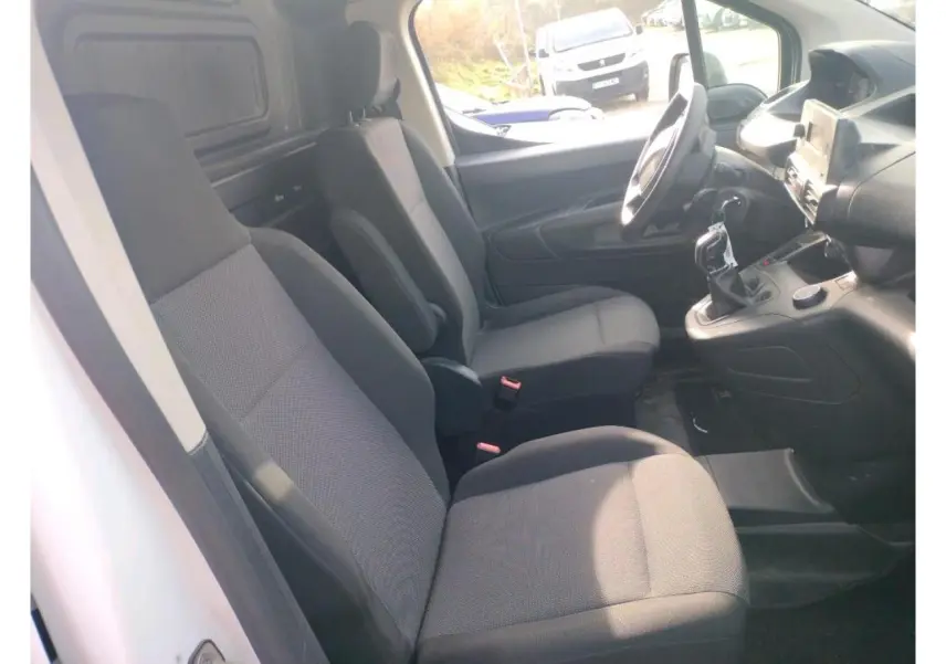 Vue 3/4 arrière droite d’un utilitaire Peugeot Partner blanc, version Standard 1.5 BlueHDi 100 Premium, sur terrain gravillonné.