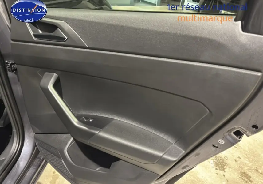 Vue rapprochée de la porte avant gauche gris cendre d'une Volkswagen Polo 2025 avec poignée intégrée et commande de vitre.