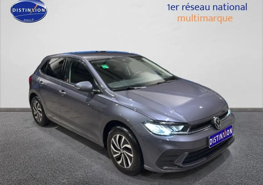 Volkswagen Polo gris cendre vue 3/4 avant droit avec phares LED allumés et jantes alliage 15 pouces.