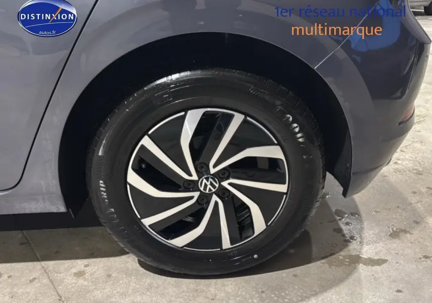 Gros plan sur la roue arrière droite d'une Volkswagen Polo gris cendre avec jante alliage noire et argent.