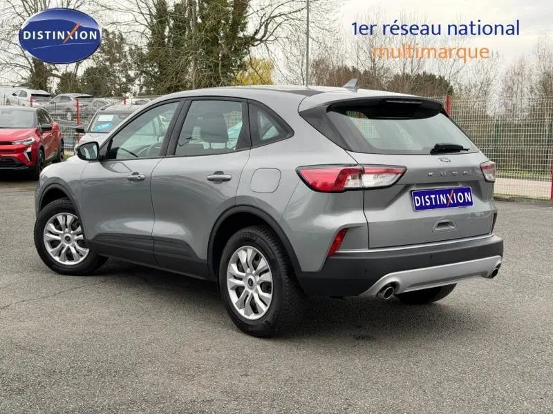 Vue 3/4 arrière droite d'un Ford Kuga 1.5 EcoBoost 150ch Titanium gris métallisé, avec échappement double et jantes alliage.