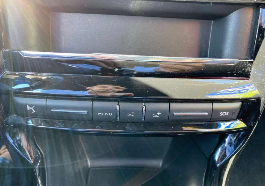 Vue rapprochée de la console centrale noire brillante du DS3 2018 avec boutons de menu et alerte SOS.