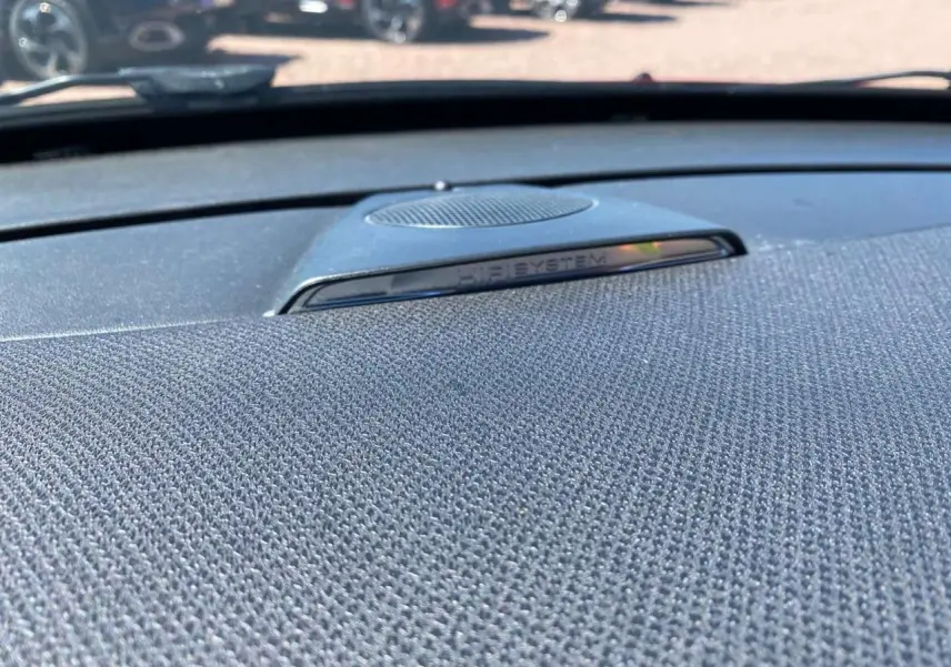 Gros plan sur le haut de la planche de bord avec haut-parleur HiFi System dans une DS3 essence rouge toit blanc.