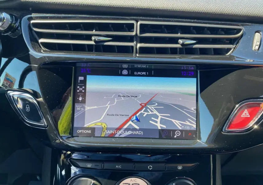 Tablette tactile centrale affichant la navigation du DS3 essence, avec commandes climatisation et bouton d’alerte rouge visibles.