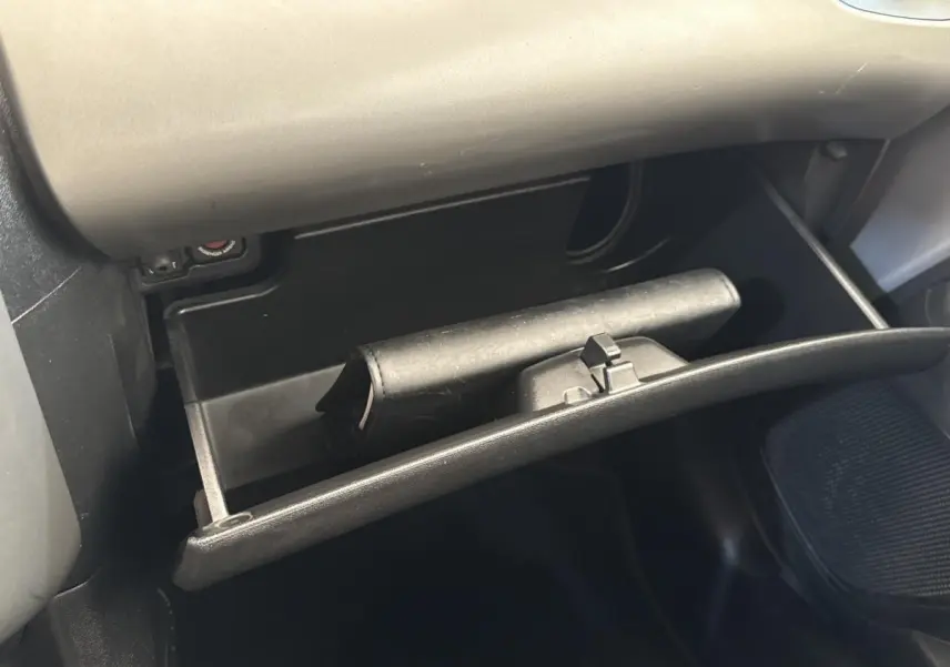 Gant de boîte à gants ouvert côté passager dans l’habitacle d’une Toyota Aygo gris clair 2017.
