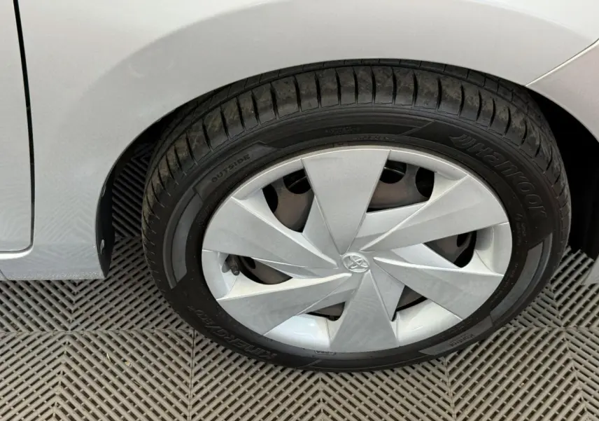 Gros plan sur la roue avant droite gris clair d'une Toyota Aygo 2017 avec enjoliveur au design géométrique.