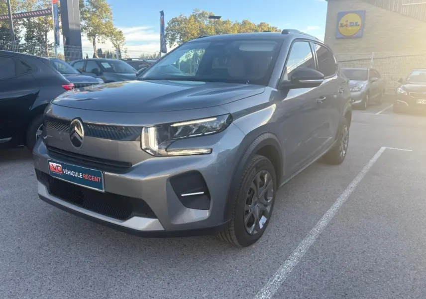 Citroën C3 Turbo 100 ch 2025 gris foncé vue 3/4 avant droit sur parking extérieur ensoleillé.
