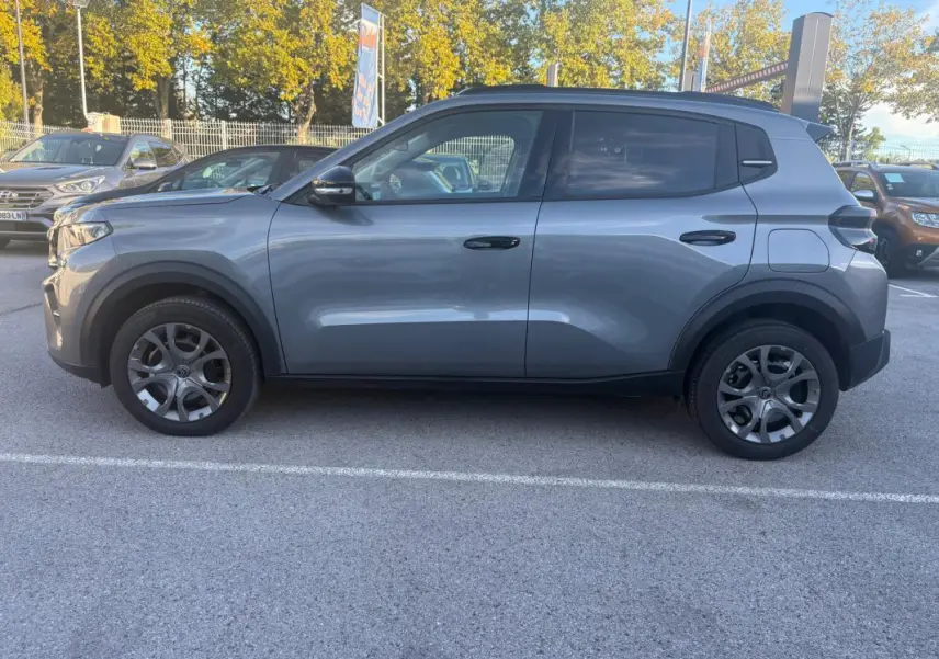 Citroën C3 2025 gris foncé vue de profil côté gauche, avec jantes distinctives et lignes modernes.
