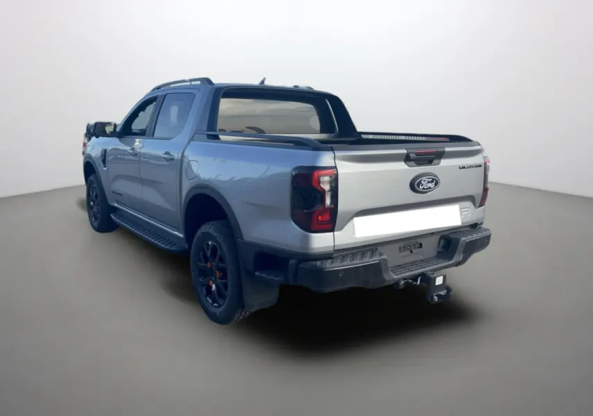 Ford Ranger Wildtrak gris iconic vu en 3/4 arrière droit avec barres de toit et attelage visible.