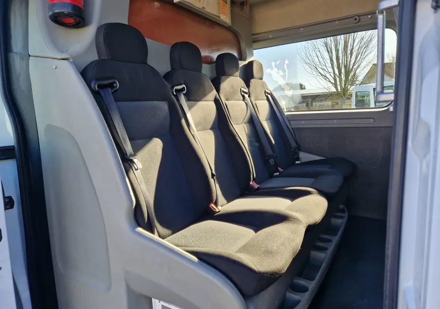 Vue intérieure côté droit montrant les quatre sièges noirs du Renault Master Cabine Approfondie blanc de 2019.