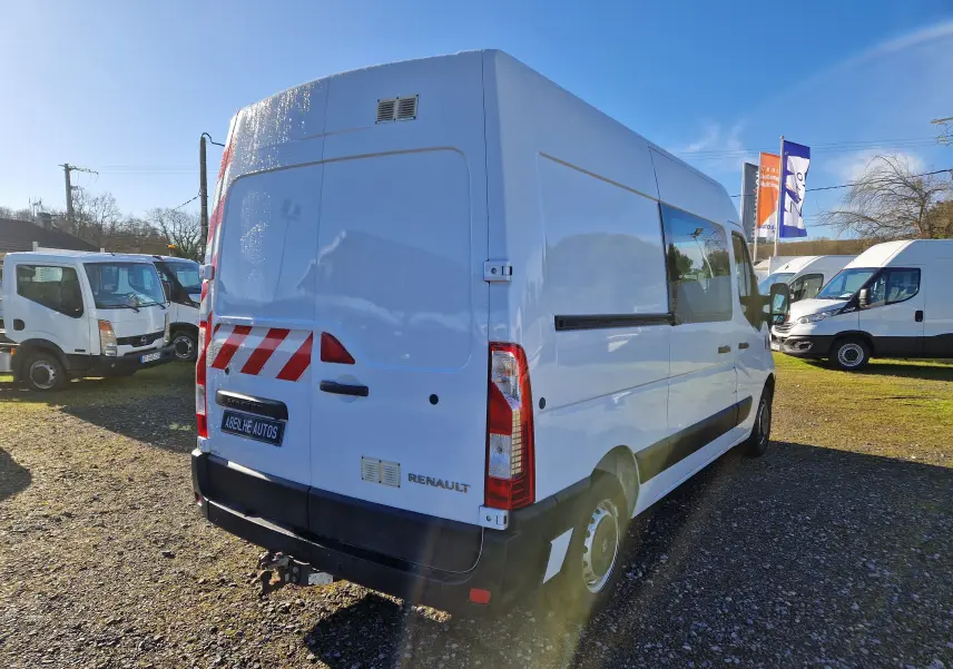 Renault Master cabine approfondie blanc vu 3/4 arrière droit avec bandes rouges réfléchissantes et attelage.