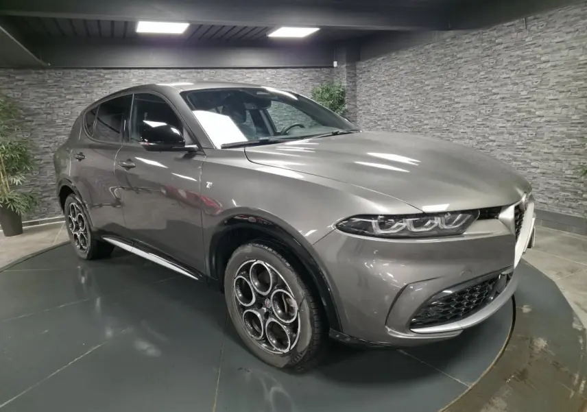 Vue 3/4 avant gauche d'une Alfa Romeo Tonale gris métallisé avec jantes 18 pouces et rétroviseurs noirs brillants.