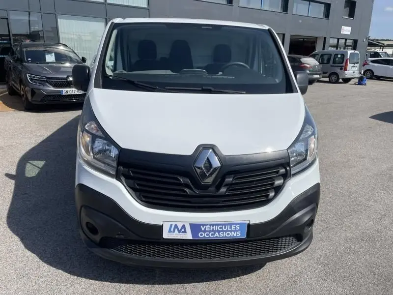 Vue de face d’un Renault Trafic Fourgon blanc L1H1 DCI 125 cv, avec calandre noire et plaque « Véhicules Occasions ».