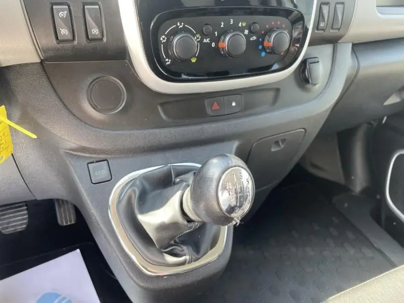 Intérieur du Renault Trafic Fourgon 2017, vue rapprochée de la boîte manuelle et commandes de climatisation sur tableau de bord noir.