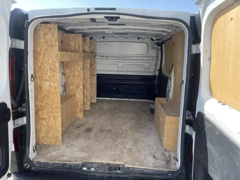 Vue intérieure arrière du Renault Trafic Fourgon blanc 2017, montrant l'espace de chargement avec aménagements en bois.