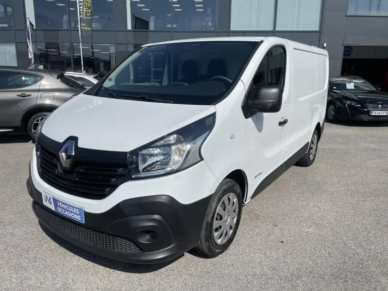 Renault Trafic Fourgon blanc en vue 3/4 avant droit, avec calandre noire et pare-chocs noir mat visible.
