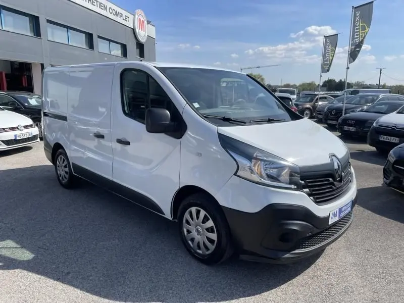 Vue 3/4 avant droit d’un Renault Trafic Fourgon blanc 2017 avec calandre noire et pare-chocs avant noir.