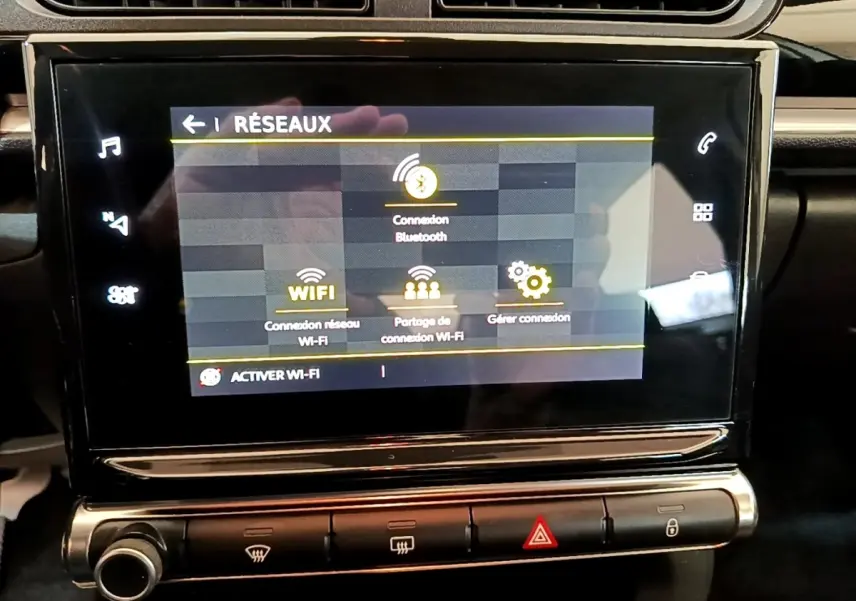 Écran tactile central du tableau de bord de la Citroën C3 blanche, affichant les options de connexion réseau Wi-Fi et Bluetooth.