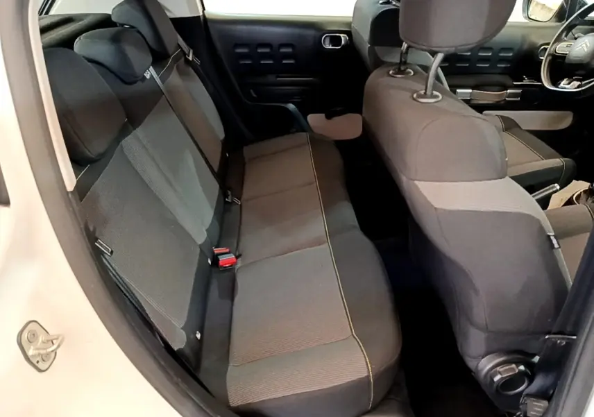 Vue intérieure côté gauche montrant la banquette arrière noire et grise de la Citroën C3 blanche 2021.