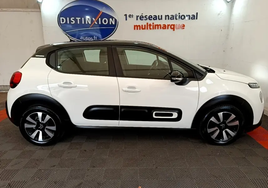 Profil droit d'une Citroën C3 blanche 2021 avec toit noir et protections latérales noires distinctives.