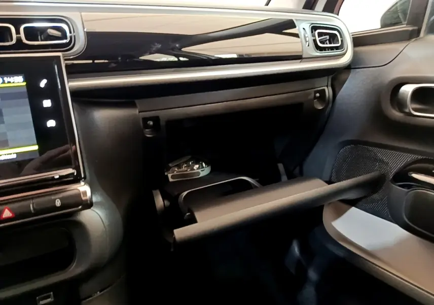 Intérieur de la Citroën C3 2021 blanc, vue du tableau de bord côté passager avec boîte à gants ouverte.