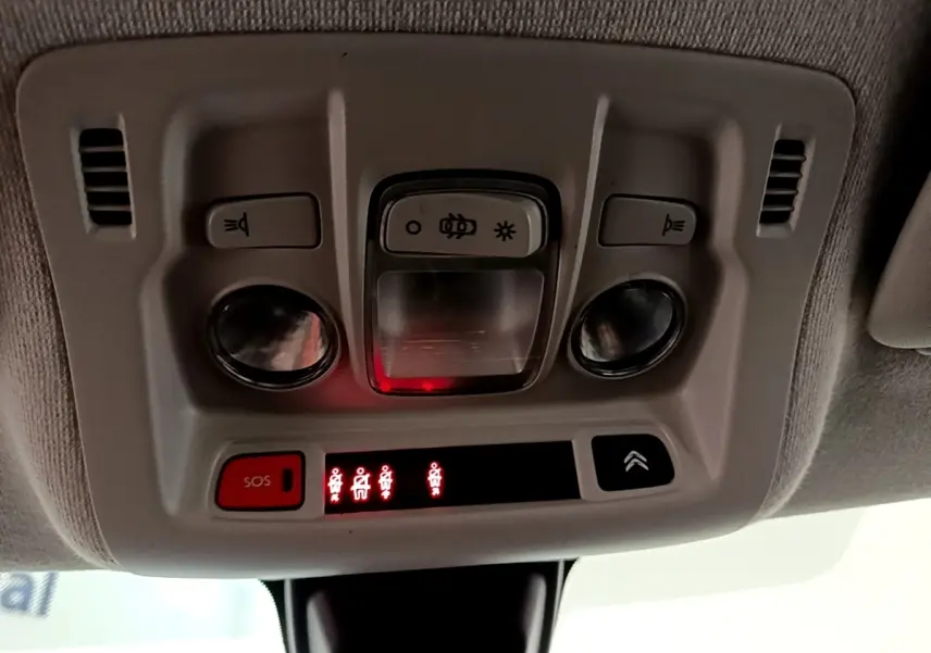 Vue en gros plan du plafonnier intérieur de la Citroën C3 blanche, avec boutons d’éclairage et alerte SOS allumée.